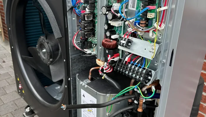 Ein offenes Gehäuse einer Wärmepumpe zeigt die interne Elektronik und Komponenten, die für die Funktion verantwortlich sind.