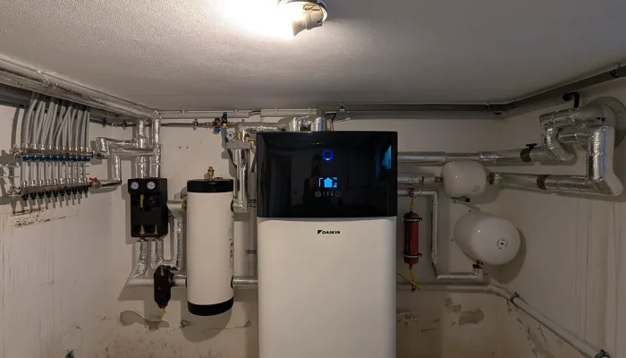 Moderne Heizungsanlage in einem Technikraum mit Rohren und Zubehör.